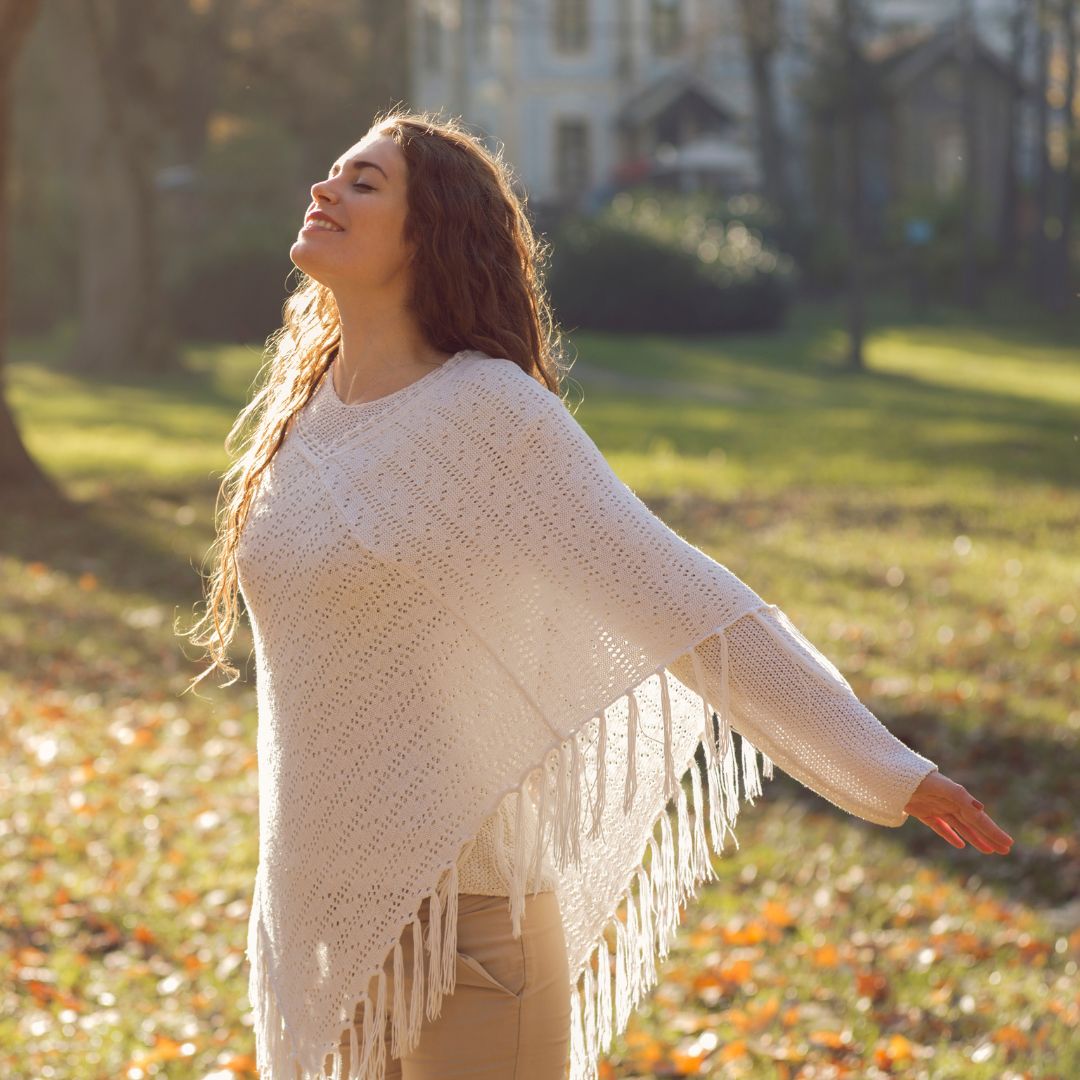 Chica con los ojos cerrados, respira en un espacio abierto de bosque primaveral