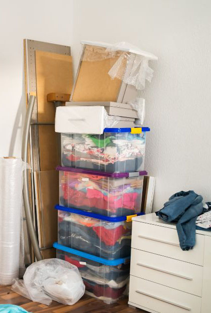 un esquinazo desordenado con cajas de ropa y tableros