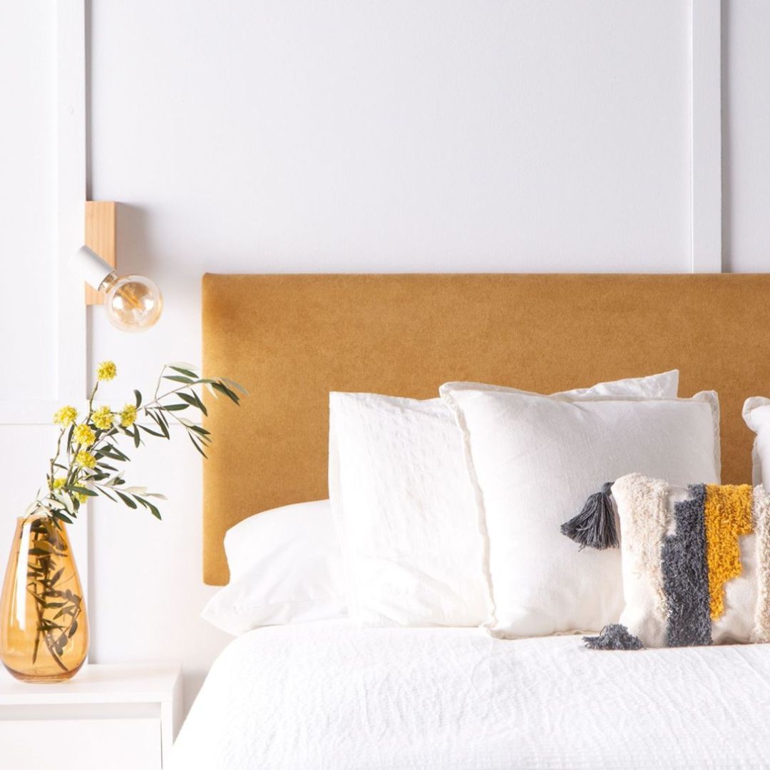 Cabecero en toco ocre en un espacio blanco